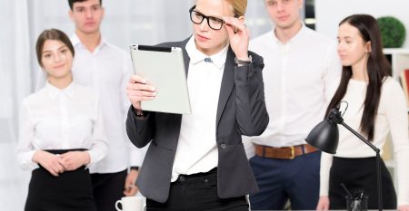 Mlody Bizneswoman Patrzeje Cyfrowa Pastylki Pozycje Przed Ludzmi Biznesu W Biurze 23 2148073325