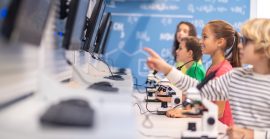 Children Standing Sideways To Camera Looking At Charge Boards Children Standing Sideways To Camera Looking At Charge Boards
